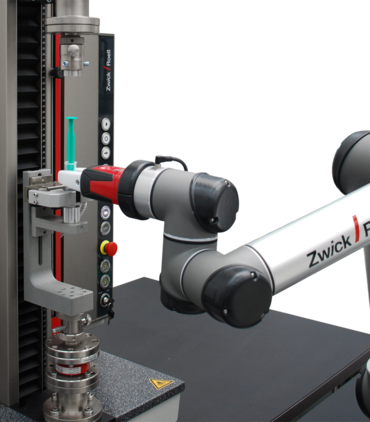 Робот легкой конструкции roboTest N располагает шприц в испытательной машине и автоматически его испытывает